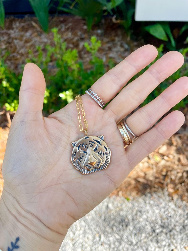 Sherry Hand Holding Gold Tiger Necklace Purchased at Palmette In Ocean Springs Mississippi