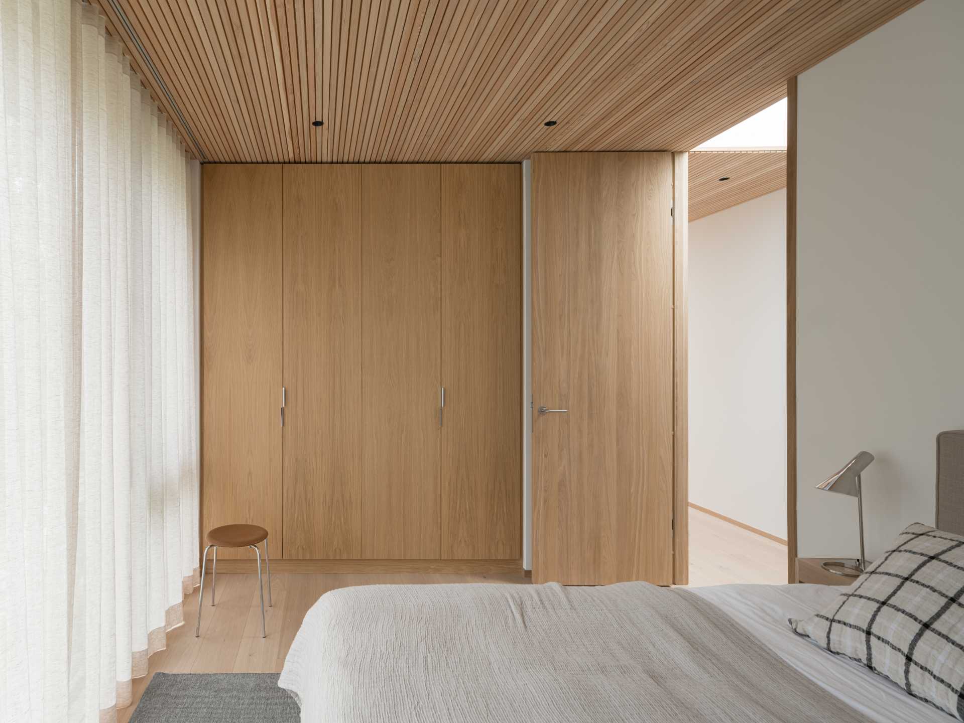 A modern bedroom with a wall of windows.