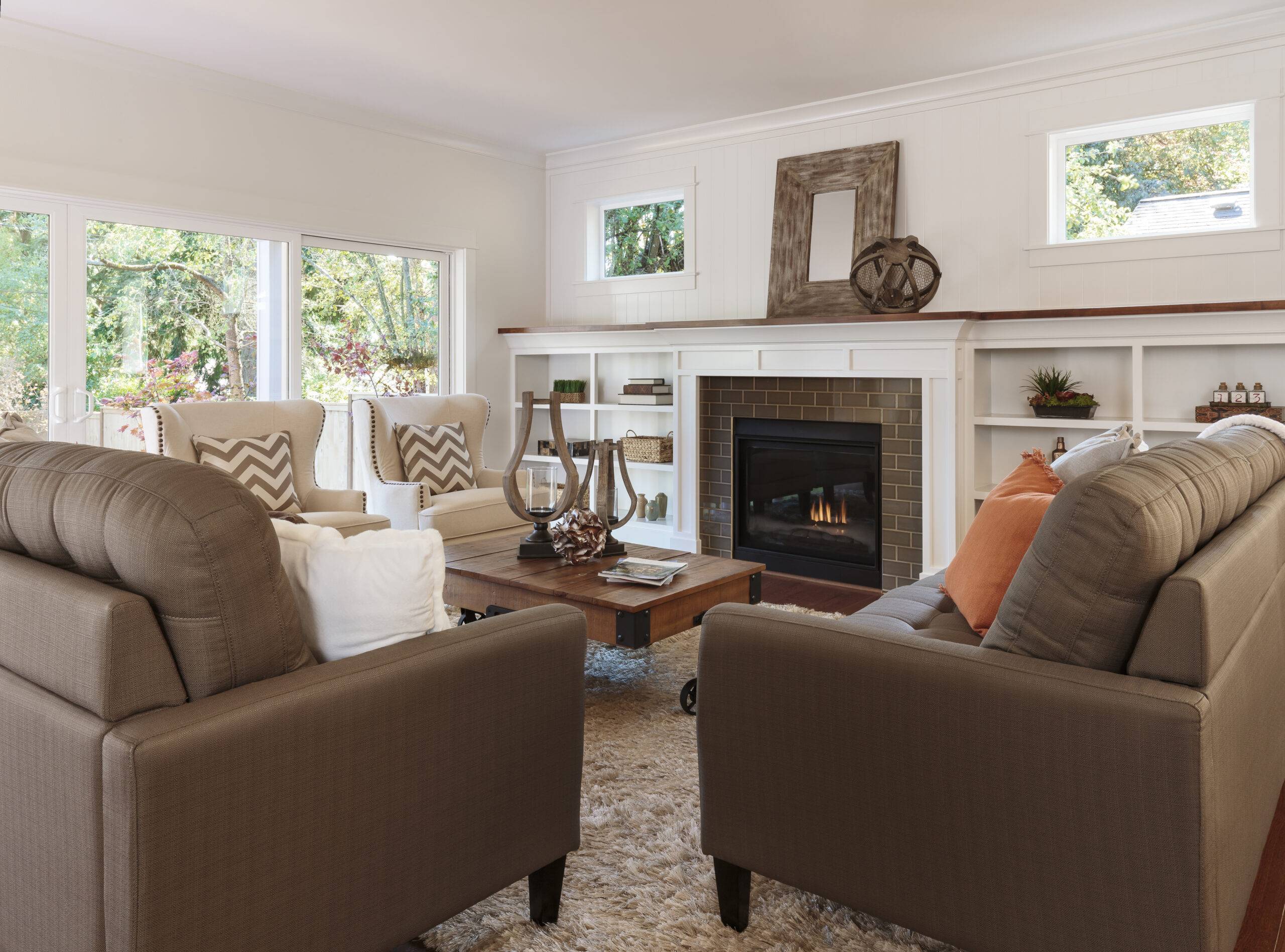 Sofas in a living room centred around a fireplace against the wall.
